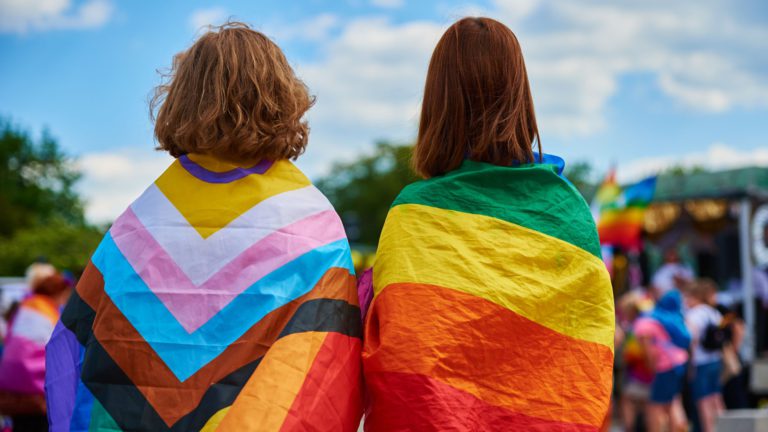 two people wearing pride flags