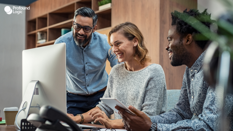 three people working on a computer in an office