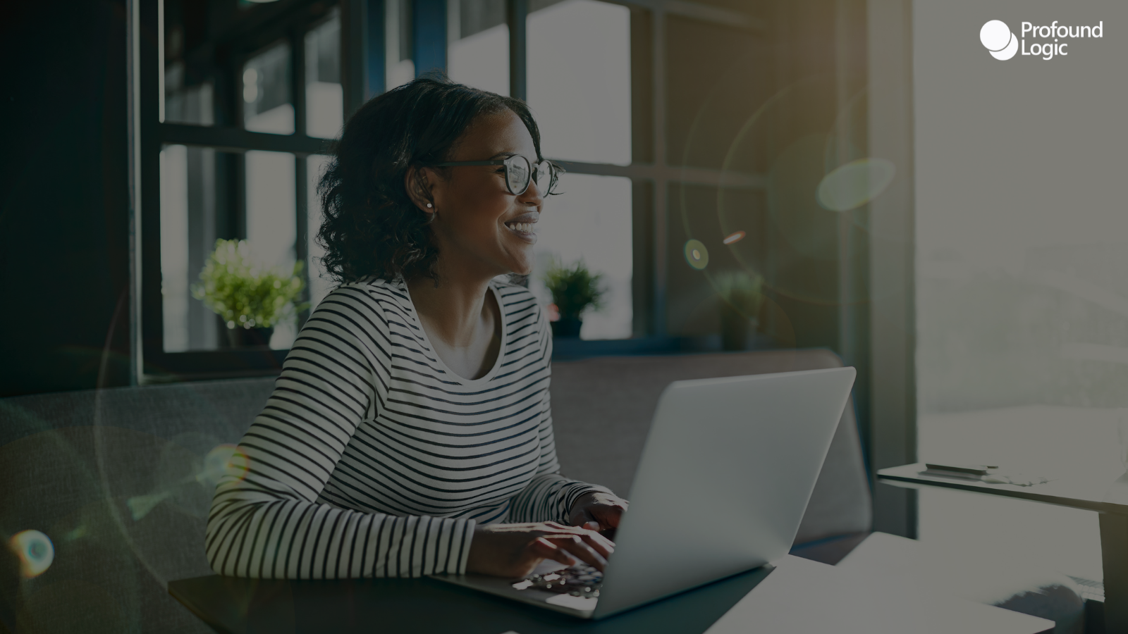 A woman sitting at a table with her laptop