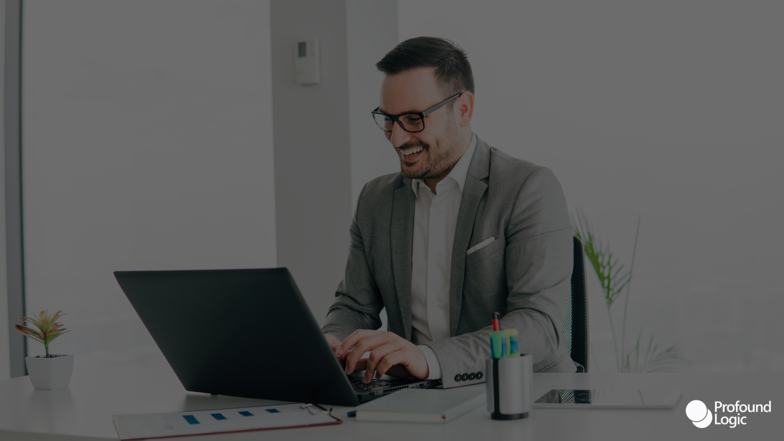 a person in a suit is working on their laptop