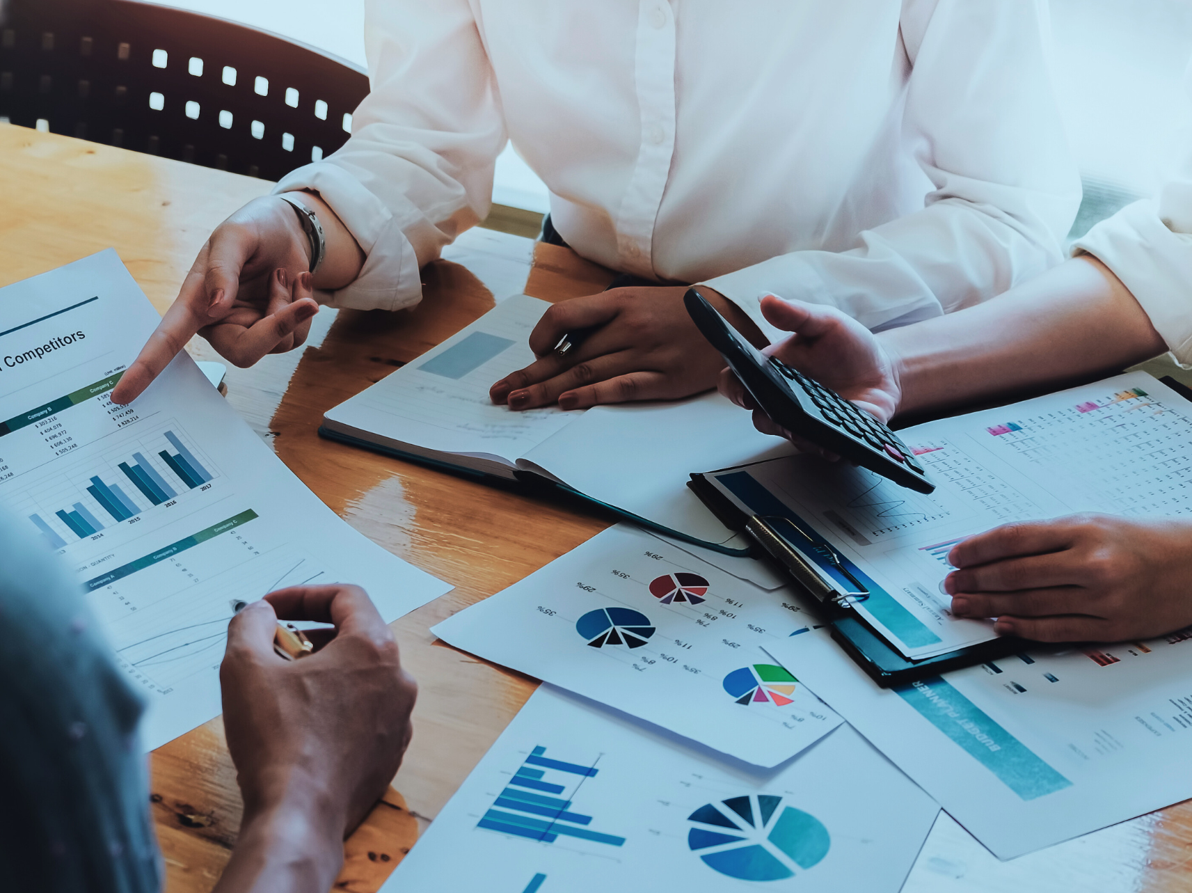 3 people working over charts