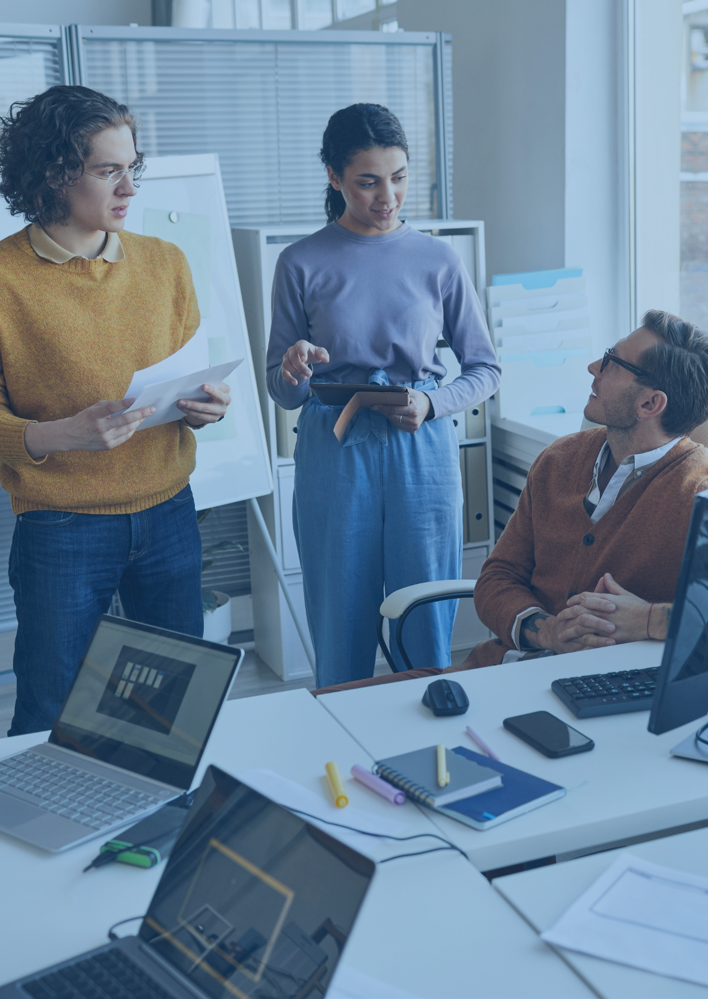 three people meeting near computers